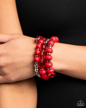 Load image into Gallery viewer, Red beaded bracelet on a wrist against a black background